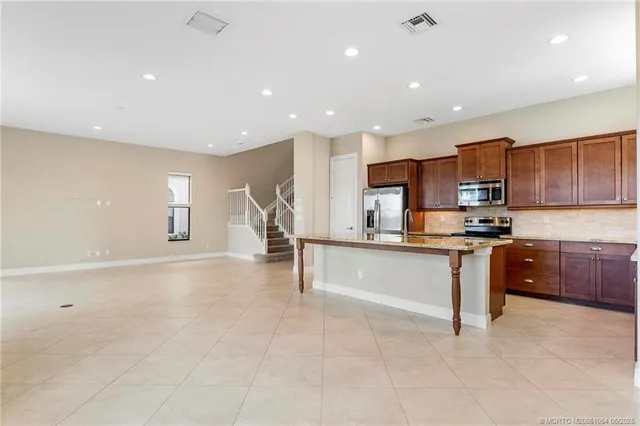 a kitchen with stainless steel appliances granite countertop a refrigerator and a stove top oven