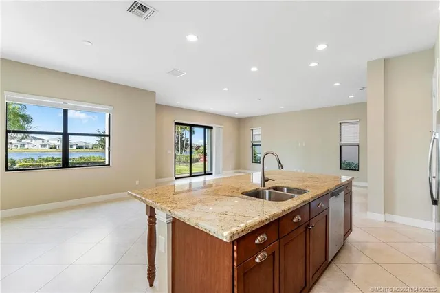 a kitchen with granite countertop sink and natural light