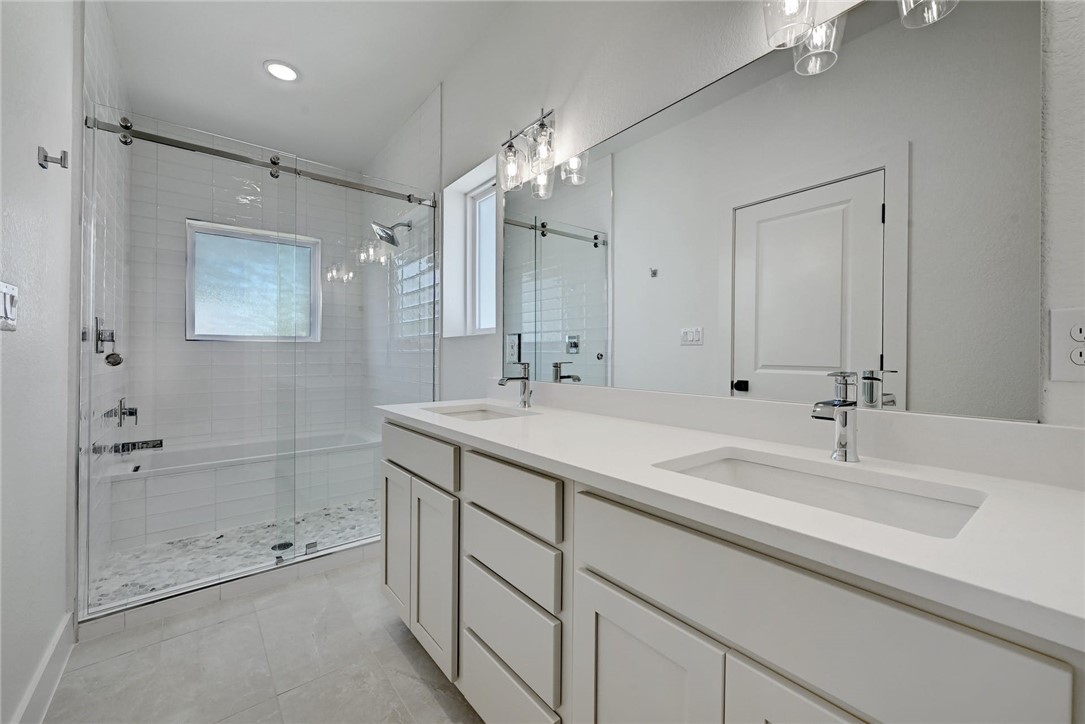 2305 Century Tree Cove Austin, TX 78723 - Photo 11 of 22 a bathroom with a double vanity sink mirror and shower