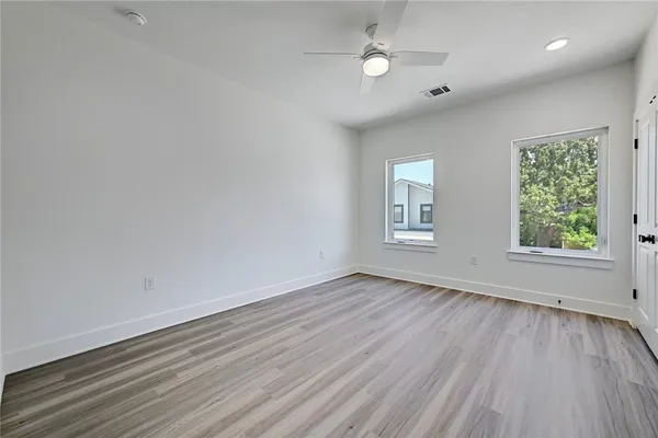 an empty room with wooden floor and windows