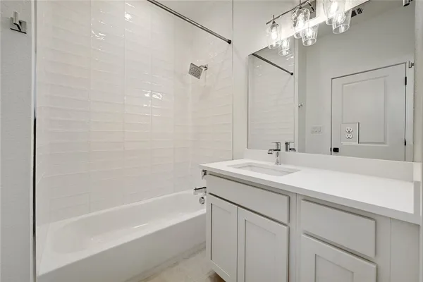 a bathroom with a sink double vanity granite tub shower and a mirror