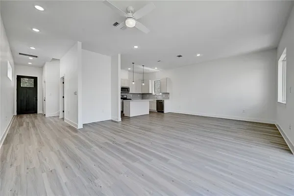 a view of empty room with wooden floor and window