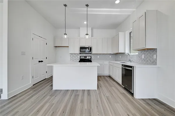 a kitchen with cabinets wooden floor and a sink