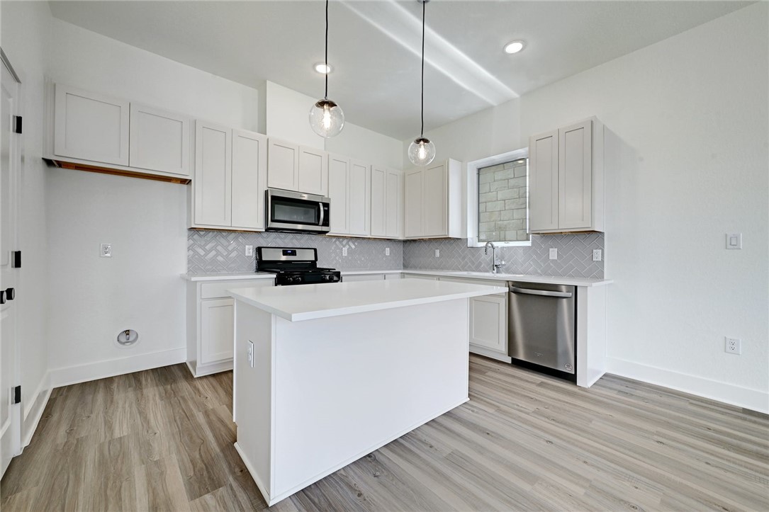 2305 Century Tree Cove Austin, TX 78723 - Photo 7 of 22 a kitchen with stainless steel appliances granite countertop a stove a sink and a microwave