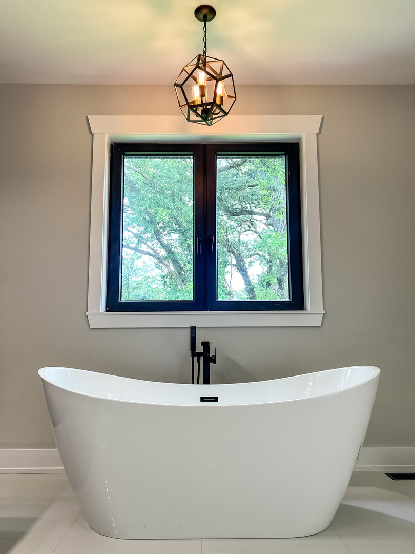 9517 Forest Place Des Plaines, IL 60016 - Photo 6 of 14 a white bath tub sitting in a bathroom next to a window