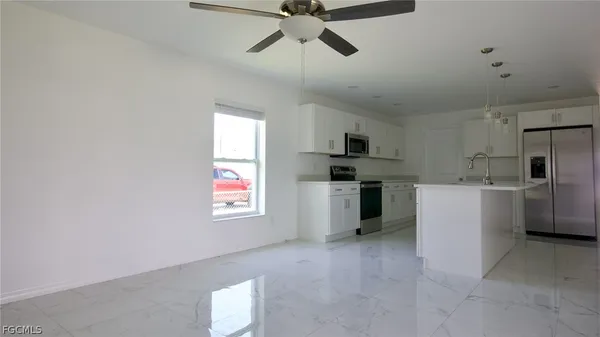 a kitchen with cabinets a window and stainless steel appliances