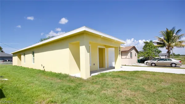 a yellow house with trees in front of it
