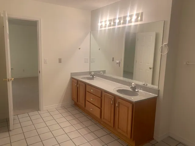 a spacious bathroom with a granite countertop sink a mirror and a