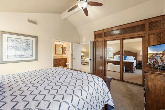 a bedroom with a large bed and a chandelier