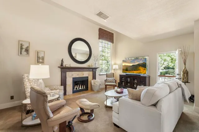 a living room with furniture a fireplace and a flat screen tv