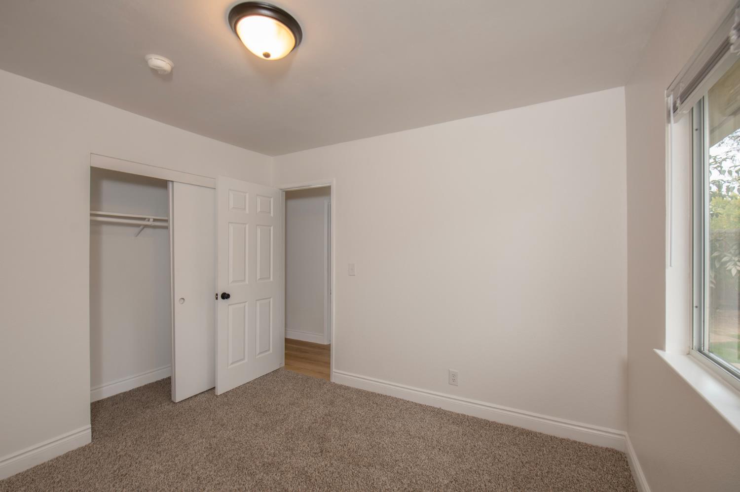 5167 East Dwight Way Fresno, CA 93727 - Photo 20 of 30 an empty room with windows and closet