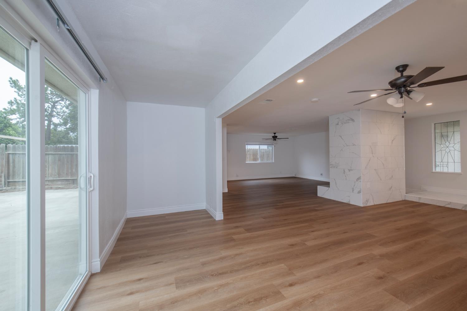 5167 East Dwight Way Fresno, CA 93727 - Photo 6 of 30 a view of a livingroom with wooden floor and a ceiling fan