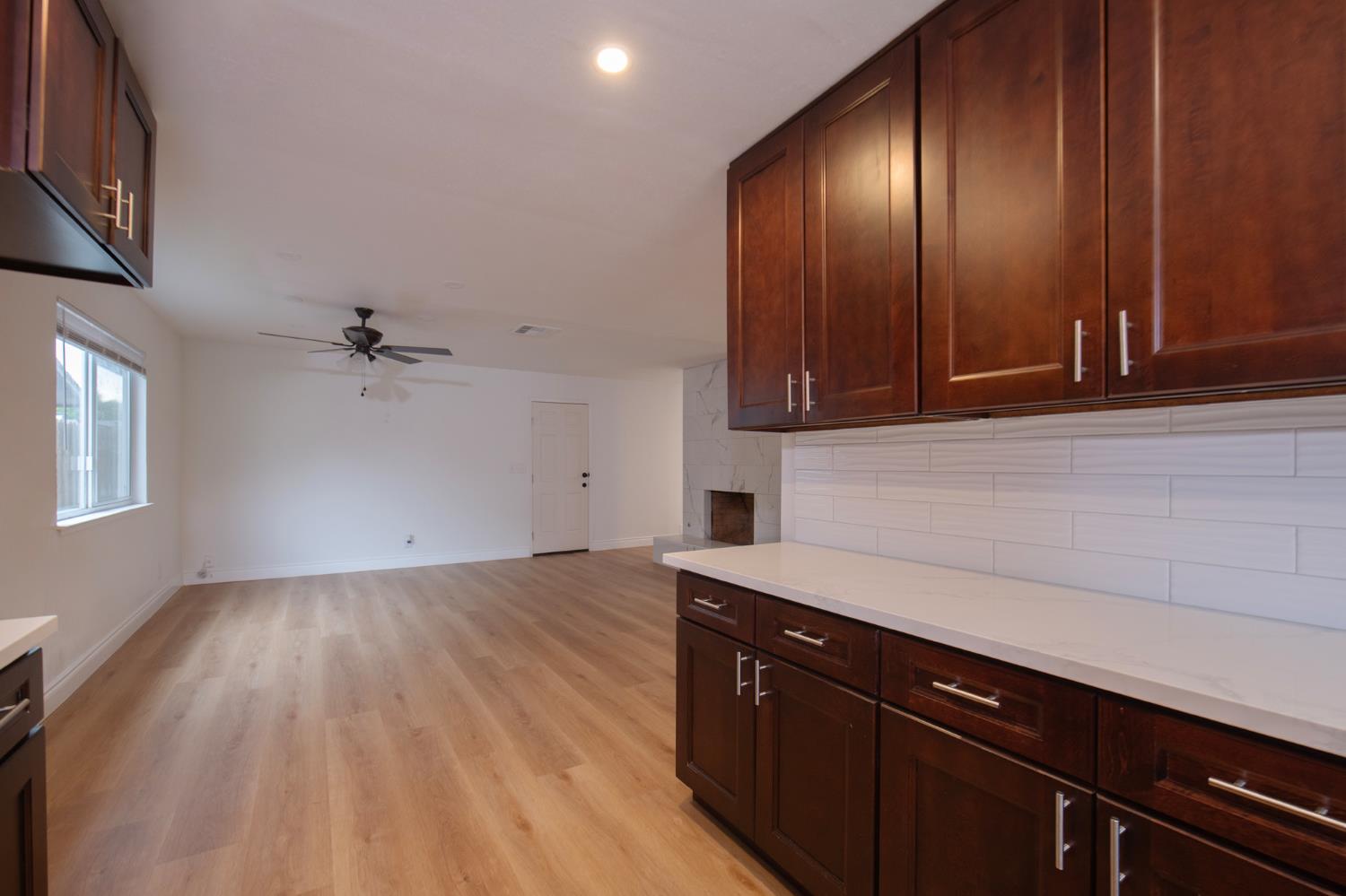 5167 East Dwight Way Fresno, CA 93727 - Photo 7 of 30 a view of a kitchen with wooden floor and cabinets