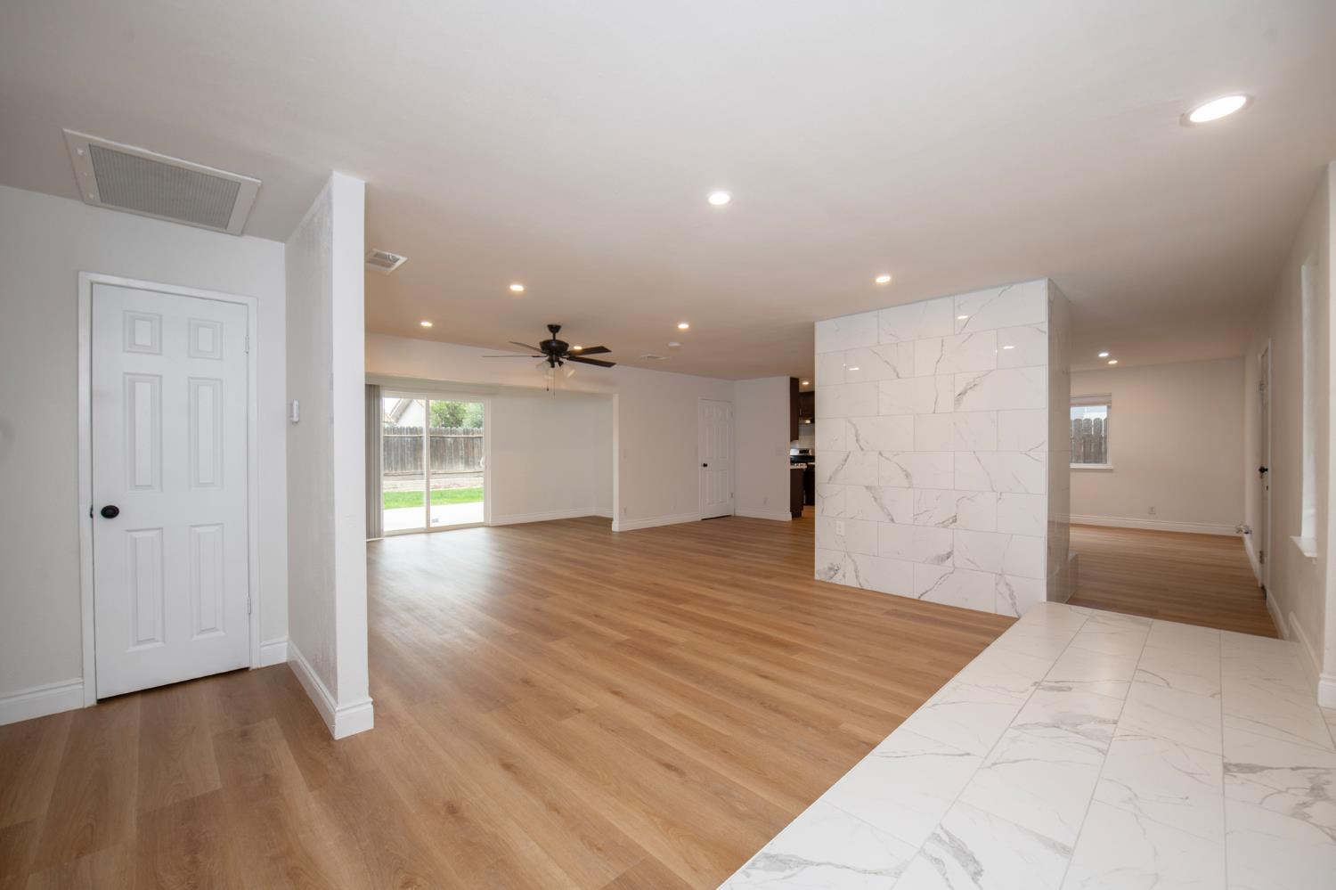 5167 East Dwight Way Fresno, CA 93727 - Photo 9 of 30 an empty room with wooden floor and windows