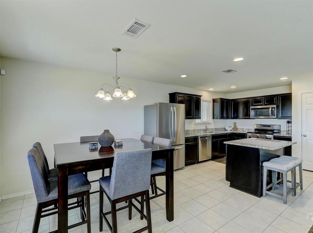 2207 Heaton Street Forney, TX 75126 - Photo 11 of 25 Open-concept kitchen and dining area featuring tile flooring, dark wood cabinetry, and stainless steel appliances