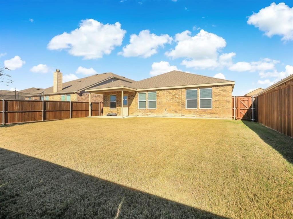 2207 Heaton Street Forney, TX 75126 - Photo 24 of 25 Spacious backyard featuring a full perimeter wooden fence, brick exterior, and covered patio