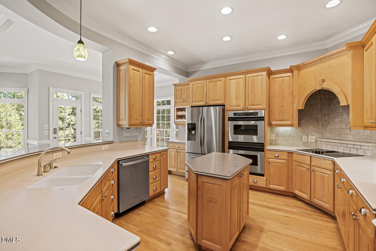 4004 Frontenac Court Apex, NC 27539 - Photo 19 of 61 a kitchen with stainless steel appliances granite countertop a sink stove and refrigerator