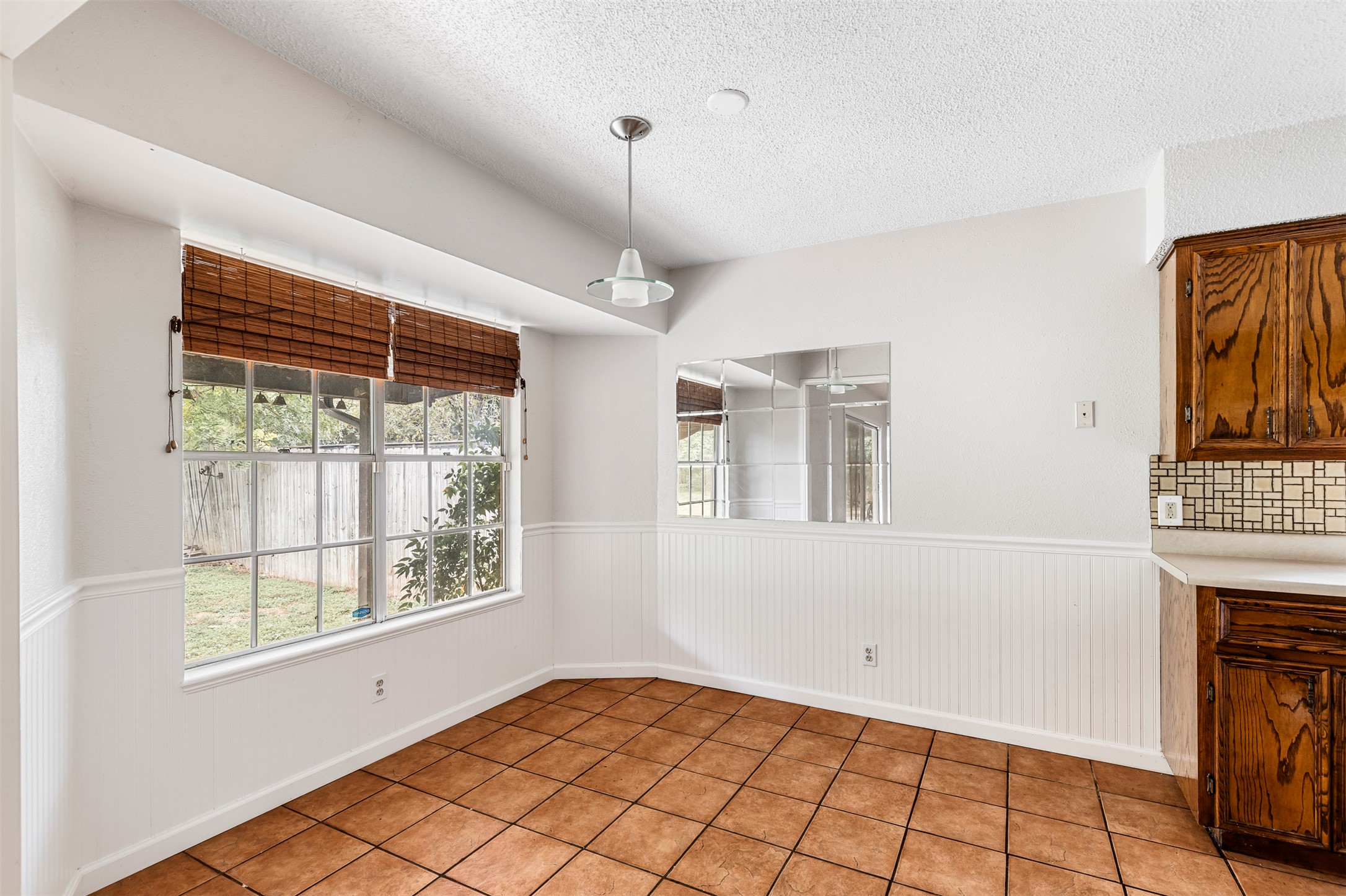 7506 Glenhill Road Austin, TX 78752 - Photo 4 of 24 A well-lit breakfast area with durable tile flooring and backyard views.