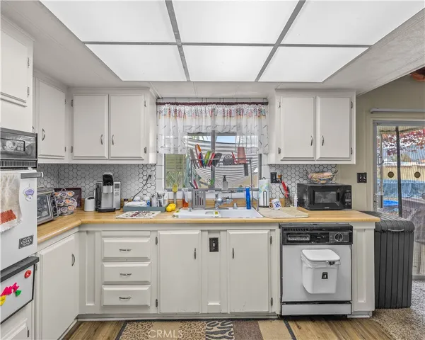 a kitchen with white cabinets and white appliances