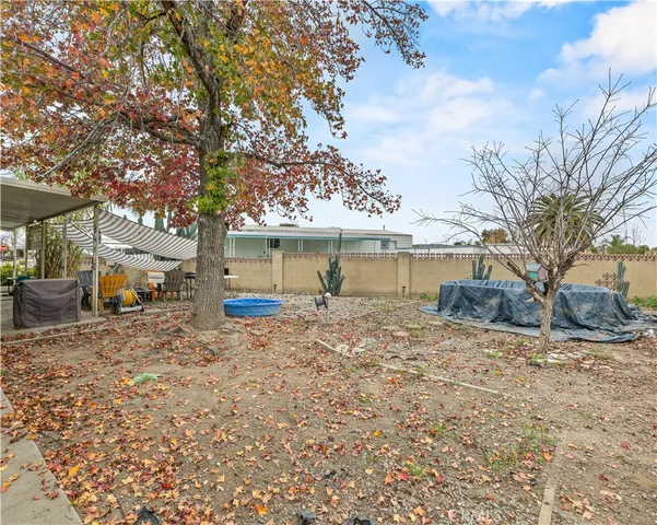 a view of a house with a yard and large tree