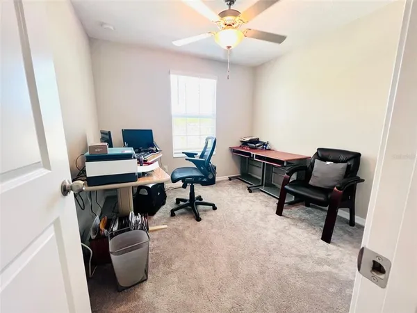 a view of a workspace with furniture and a window
