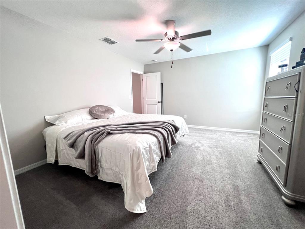 2170 Shining Azul Way Lutz, FL 33558 - Photo 9 of 11 a bedroom with a bed and a chandelier