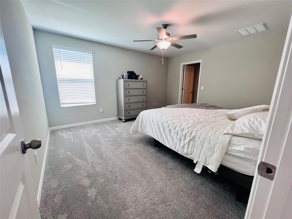 2170 Shining Azul Way Lutz, FL 33558 - Photo 10 of 11 a bedroom with a bed and a chandelier