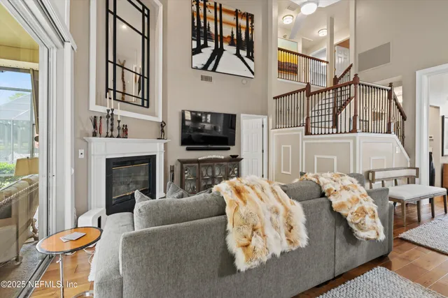 a living room with furniture a flat screen tv and a fireplace