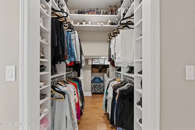 a view of walk in closet with clothes and shoes