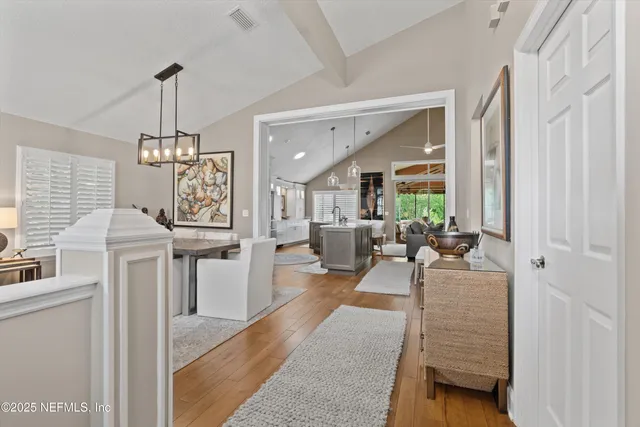 a living room with furniture a chandelier and a dining table