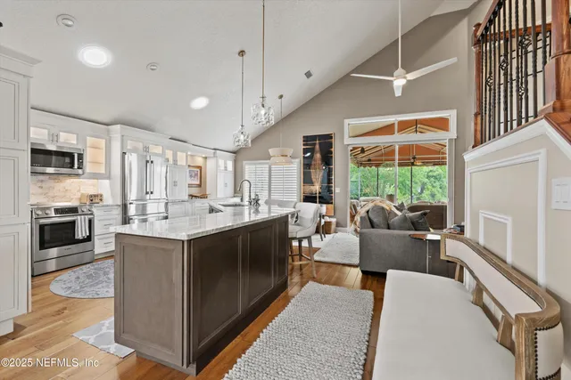 a view of kitchen with stainless steel appliances granite countertop sink stove and refrigerator
