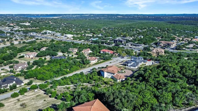 an aerial view of residential houses with outdoor space and trees