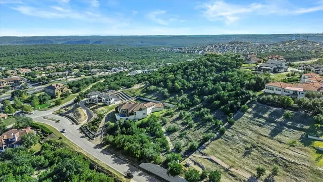 an aerial view of residential houses with outdoor space and trees