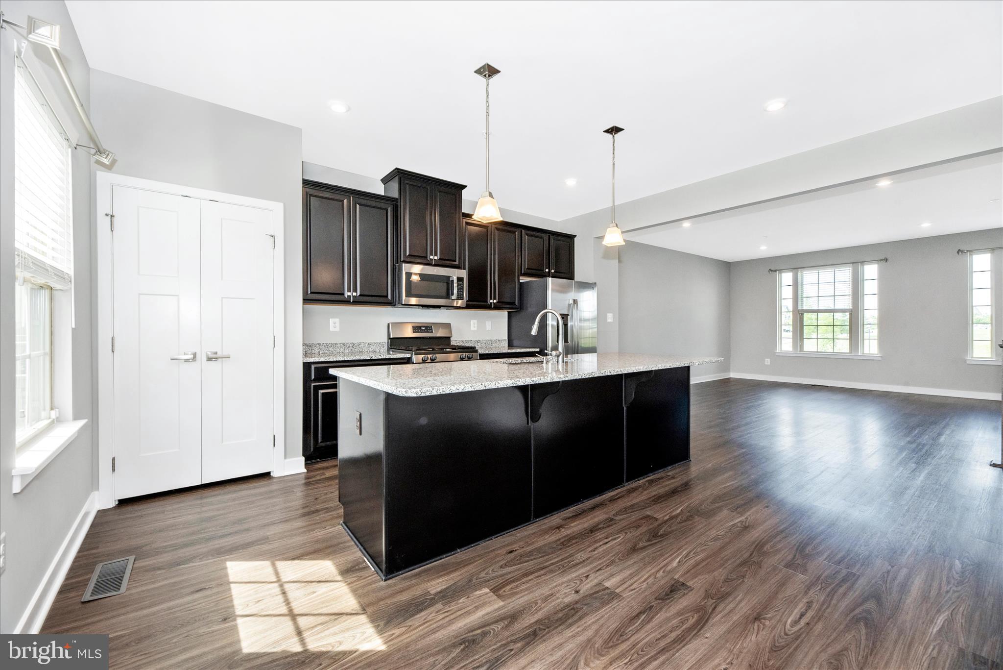 7091 Kokanee Way New Market, MD 21774 - Photo 18 of 69 a kitchen with stainless steel appliances granite countertop a refrigerator a sink dishwasher a stove and white countertops with wooden floor