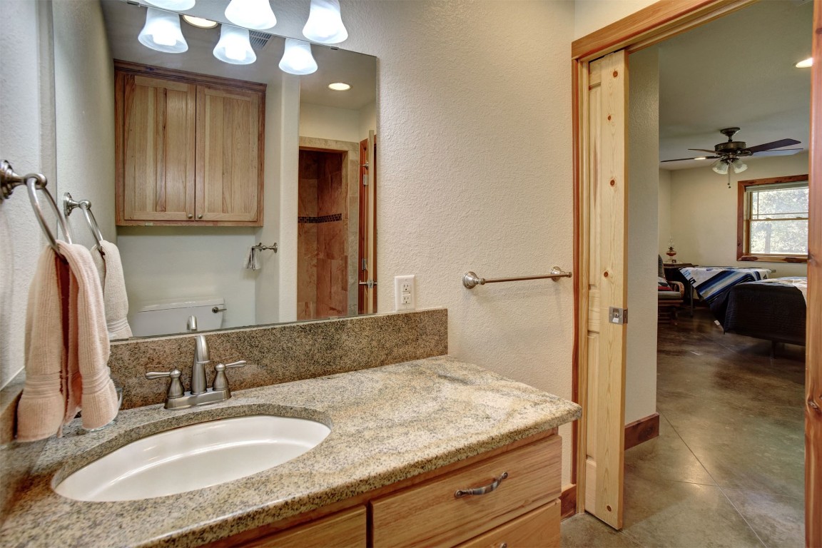 945 Justice Road West Point, TX 78963 - Photo 17 of 21 a en suite bathroom with a granite countertop sink and a mirror