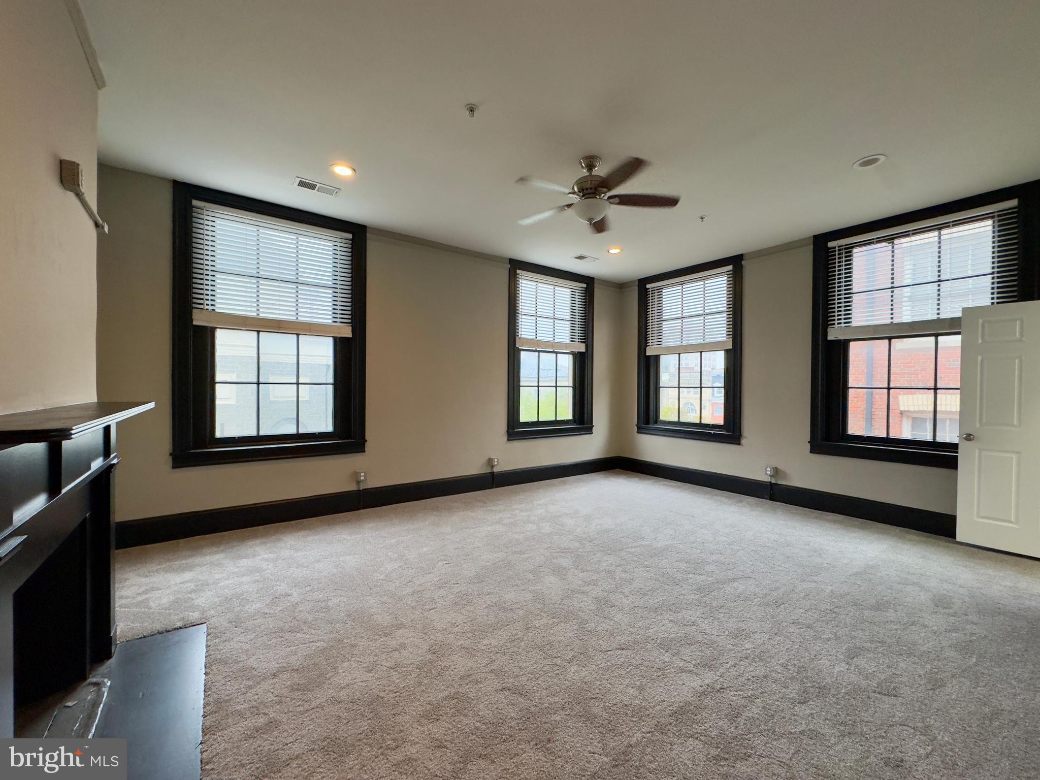7 West Mulberry Street, Unit 8 Baltimore, MD 21201 - Photo 13 of 18 a view of an empty room with a window and fireplace