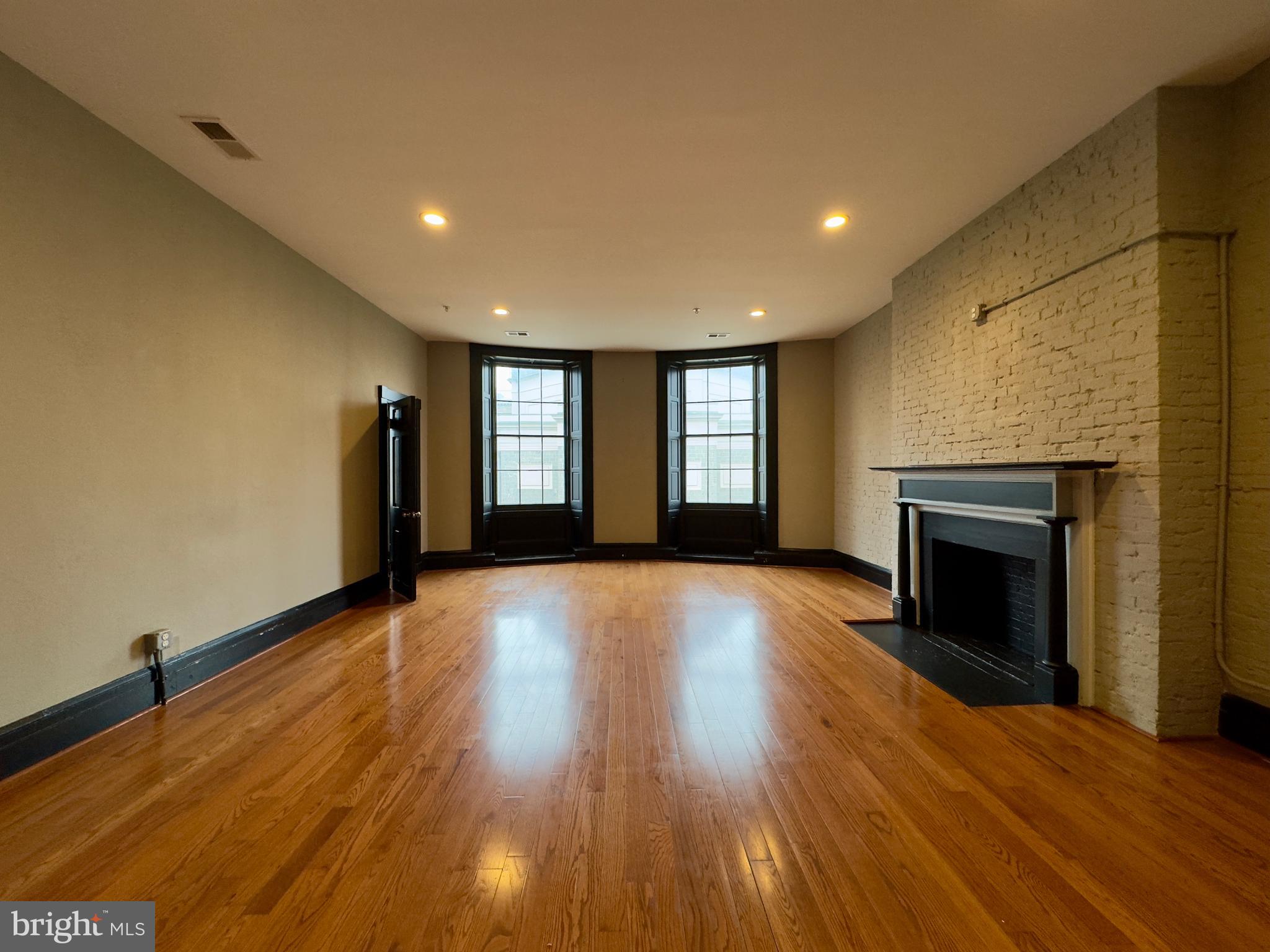 7 West Mulberry Street, Unit 8 Baltimore, MD 21201 - Photo 3 of 18 a view of an empty room with a fireplace and a window