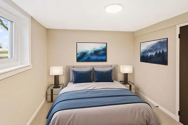 a bedroom with a bed and a painting on the wall