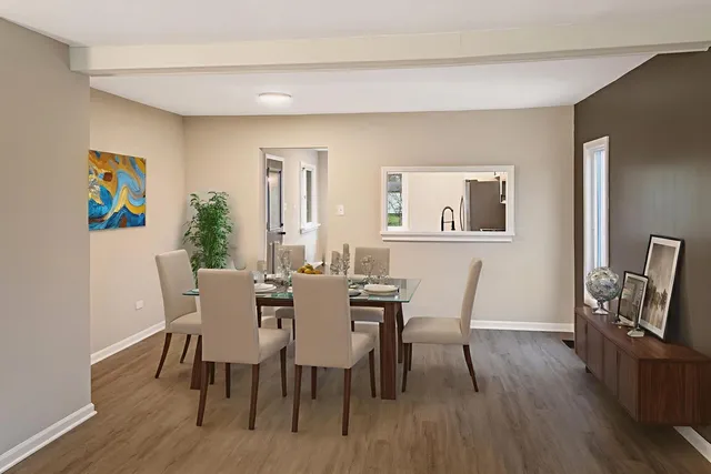 a view of a dining room with furniture a rug and wooden floor