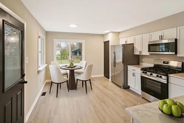 a kitchen with stainless steel appliances a kitchen island hardwood floor and a sink