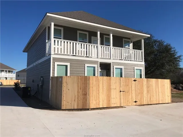 a front view of a house with a wooden fence