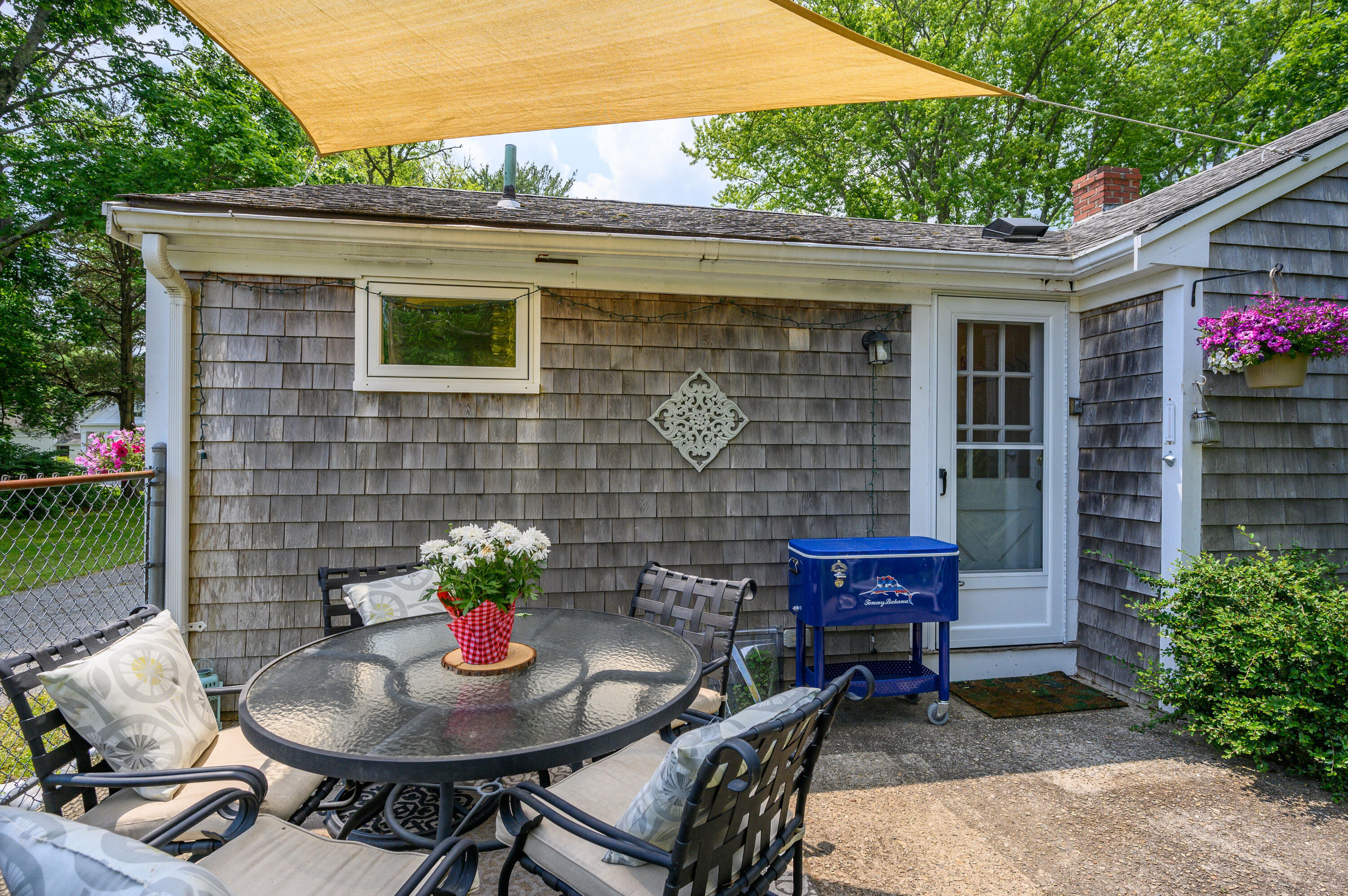 120 Main Street Cotuit, MA 02635 - Photo 31 of 40 a backyard of a house with table and chairs