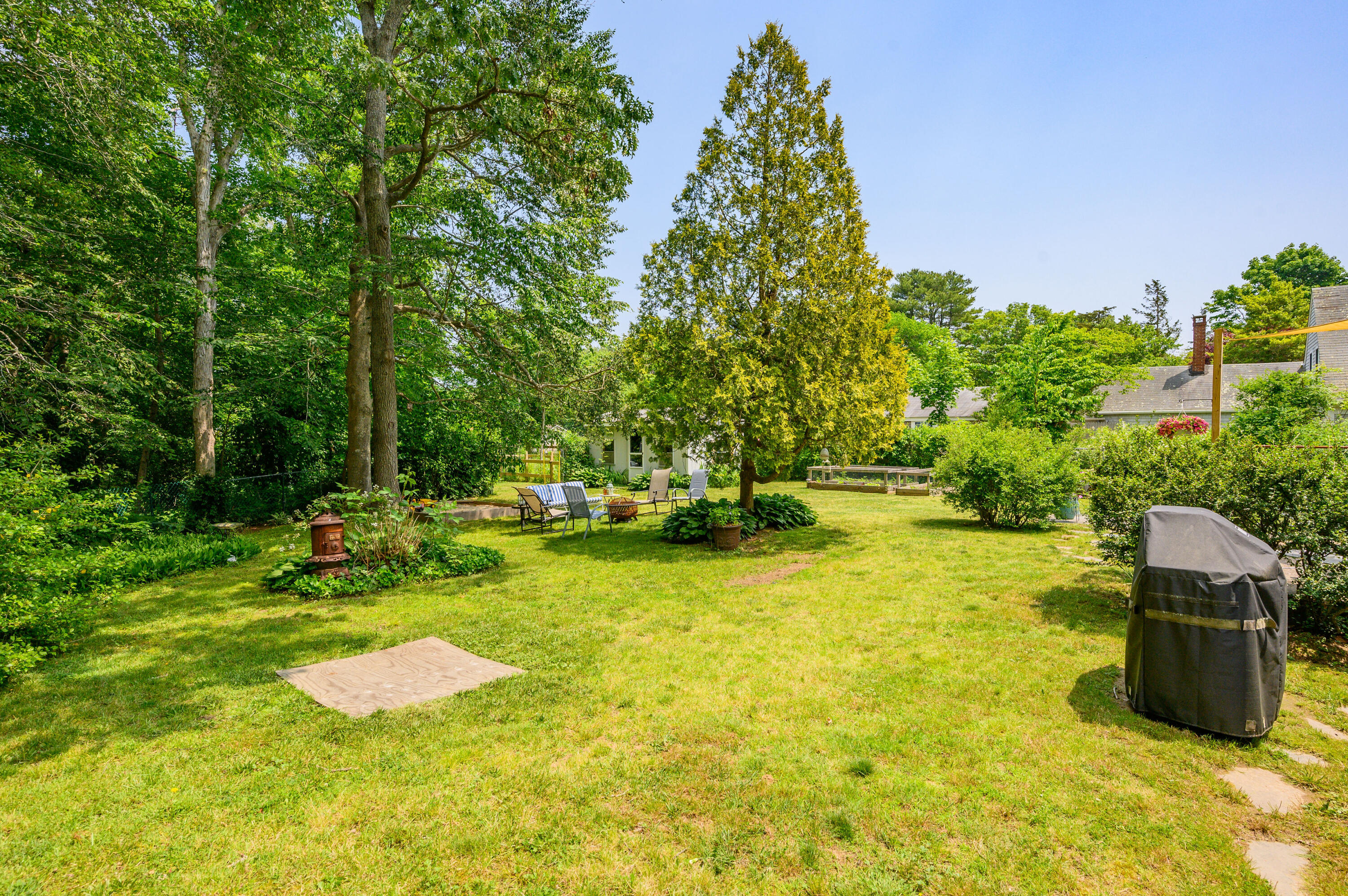 120 Main Street Cotuit, MA 02635 - Photo 38 of 40 a view of a garden with a bench