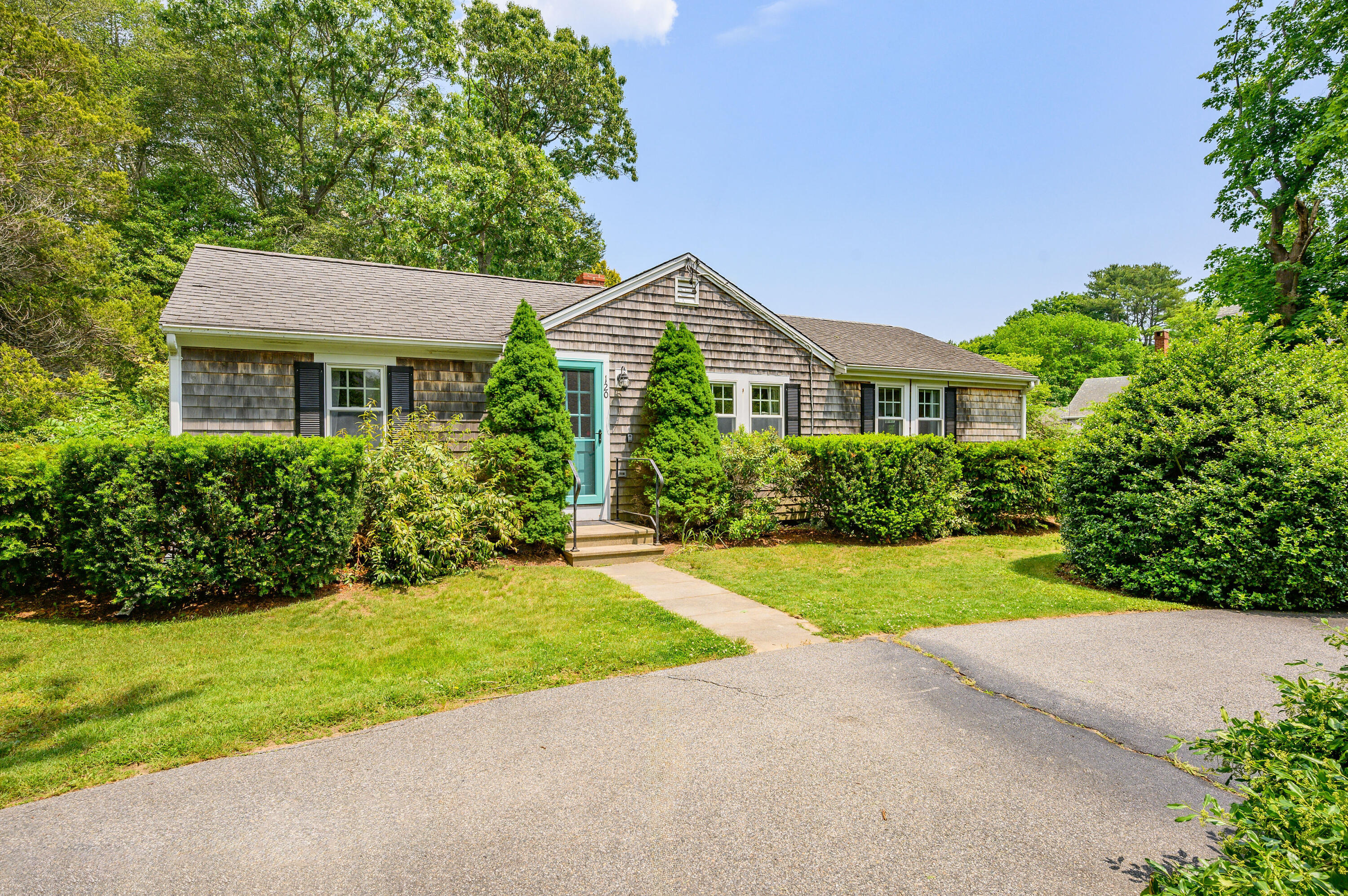 120 Main Street Cotuit, MA 02635 - Photo 4 of 40 a front view of a house with a yard and garage