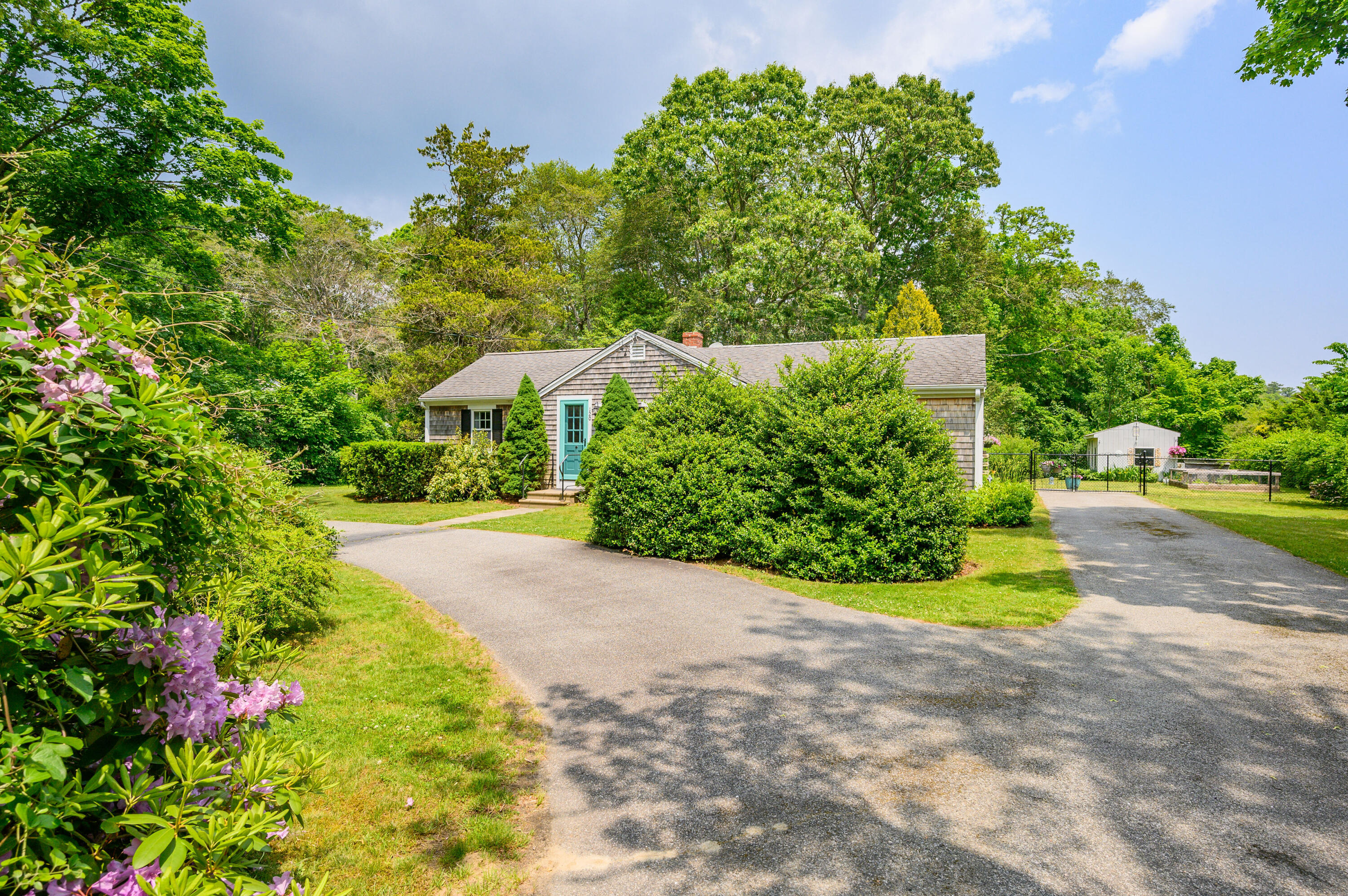 120 Main Street Cotuit, MA 02635 - Photo 5 of 40 a view of a garden with plants and large trees