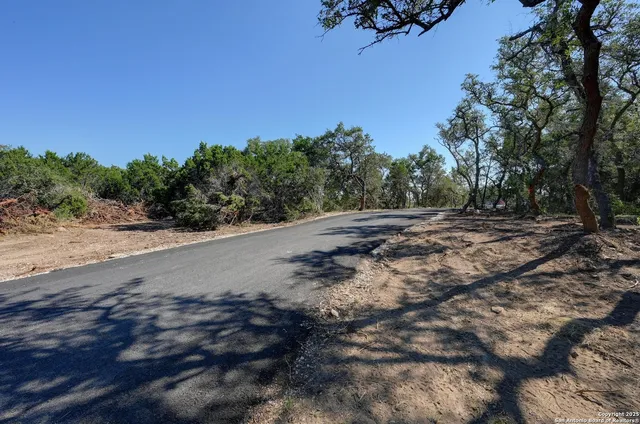 a view of a dirt road with a building in the background