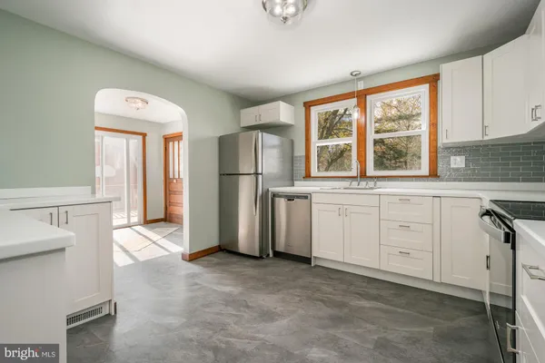 a kitchen with white cabinets and white appliances