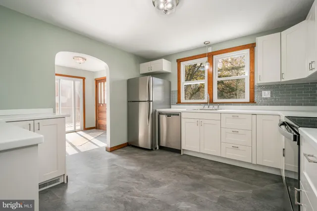 a kitchen with white cabinets and white appliances