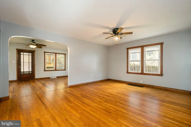a view of an empty room with window and wooden floor