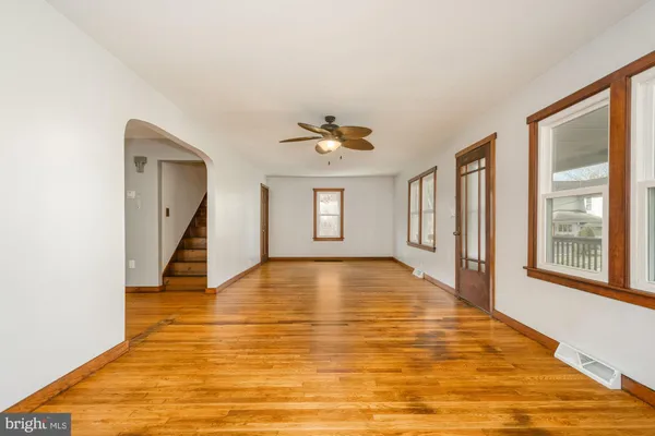 a view of an empty room with window and wooden floor